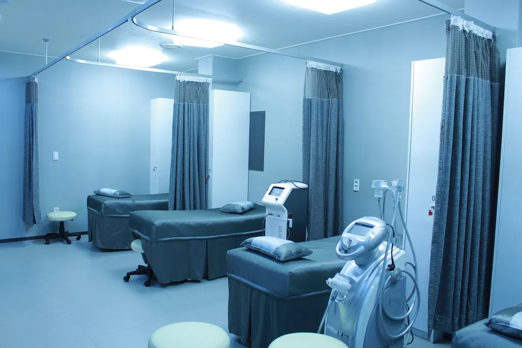 A clean clinical treatment room with curtained bays and made-up couches.